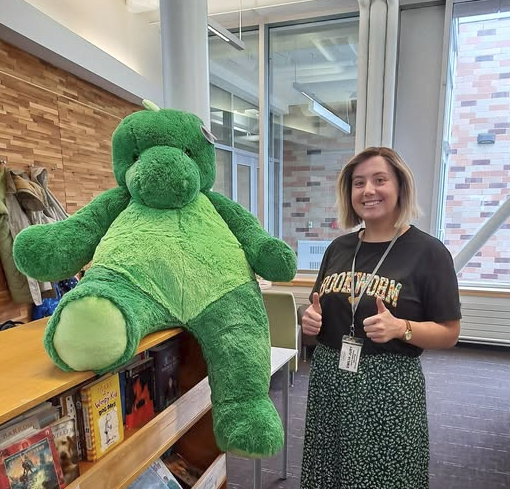 Woman next to dinosaur plushie