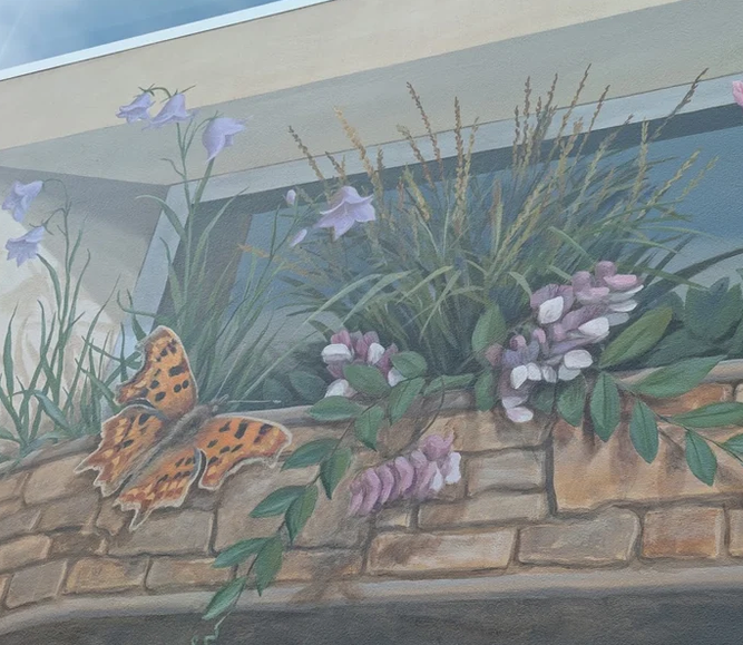 Photo of a mural depicting realistic flora and fauna. 